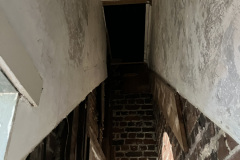 Interior of stairwell with staircase removed, looking from first floor to second floor.
