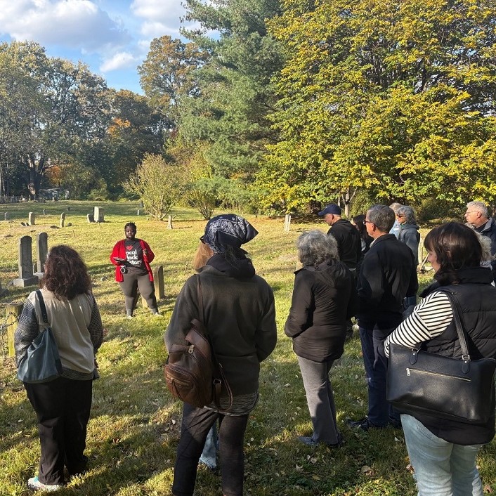 A tour guide leads a tour through a historic cemetary