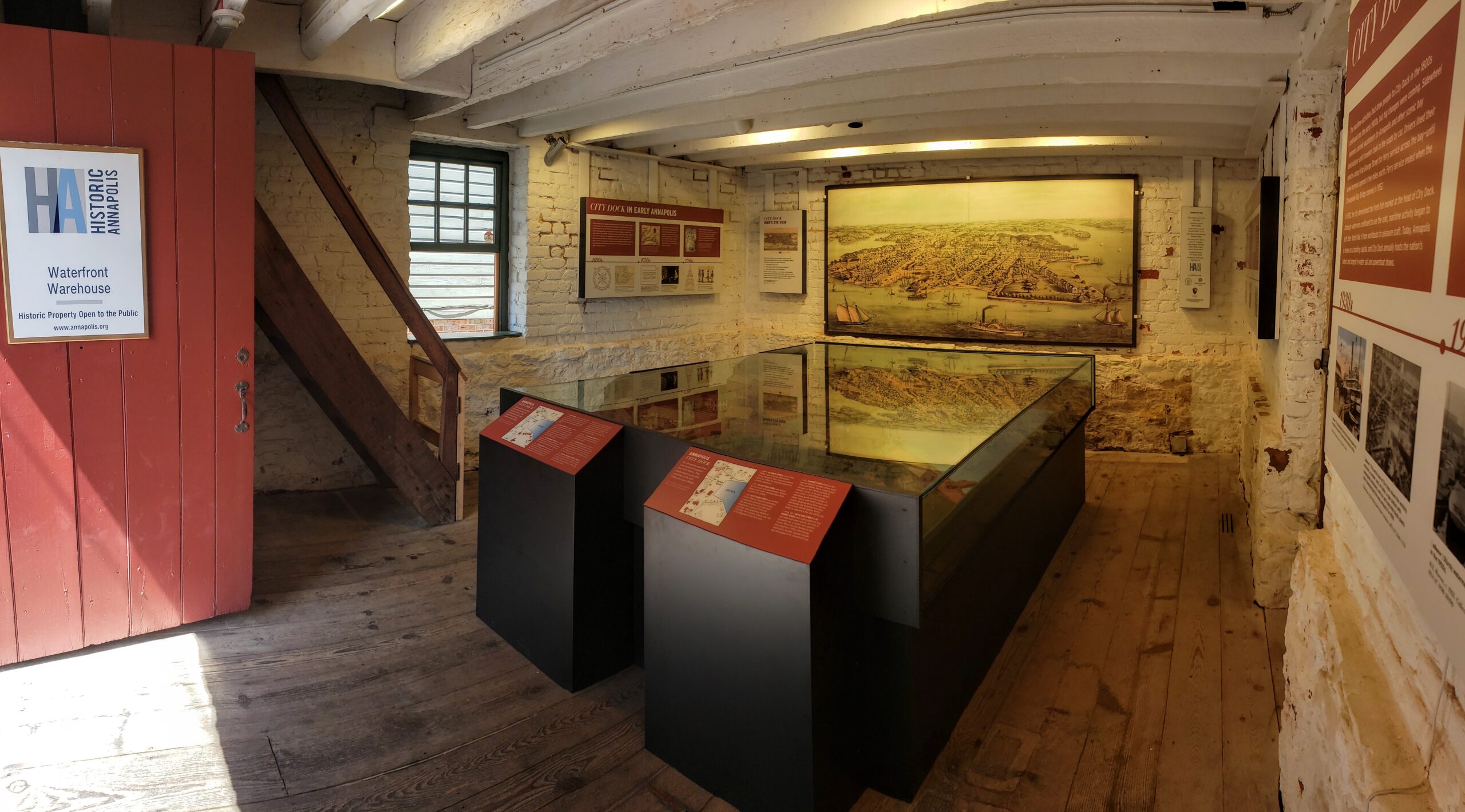 Interior view of the Waterfront Warehouse in Annapolis featuring maritime exhibits and a detailed scale model of the 18th-century waterfront and harbor.