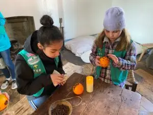 Girl Scouts decorating oranges with cloves during a hands-on history activity at Historic Annapolis.