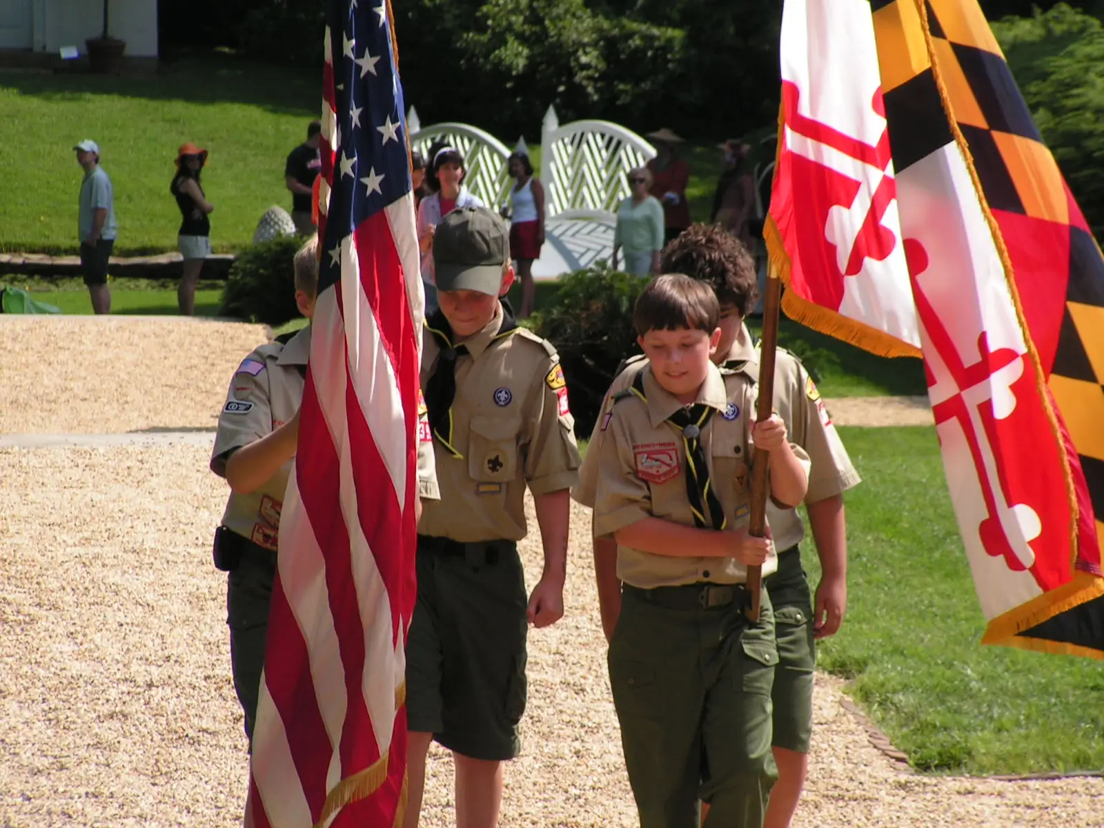 Scouts carrying the American and Maryland flags during an outdoor program in Annapolis.