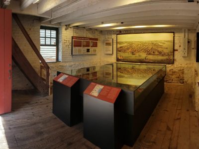 Interior view of the Waterfront Warehouse in Annapolis featuring maritime exhibits and a detailed scale model of the 18th-century waterfront and harbor.