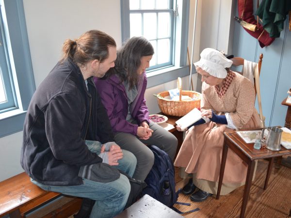 Interpreter in 18th-century dress shares stories of early Annapolis trades and daily life with museum visitors inside Hogshead.